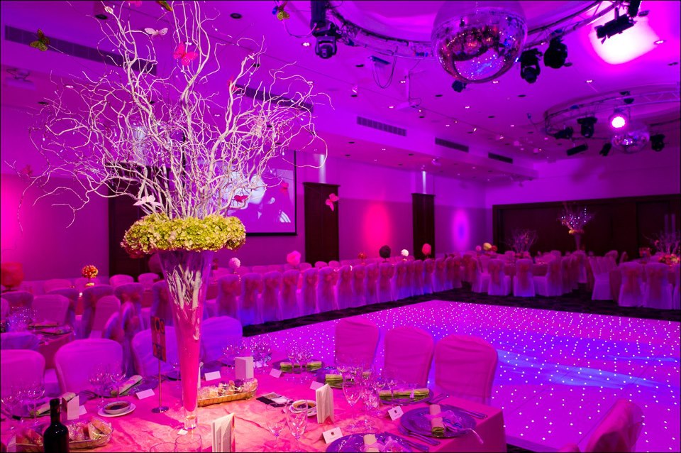 Elegant event space with pink lighting and floral arrangements at Avenue Banqueting.