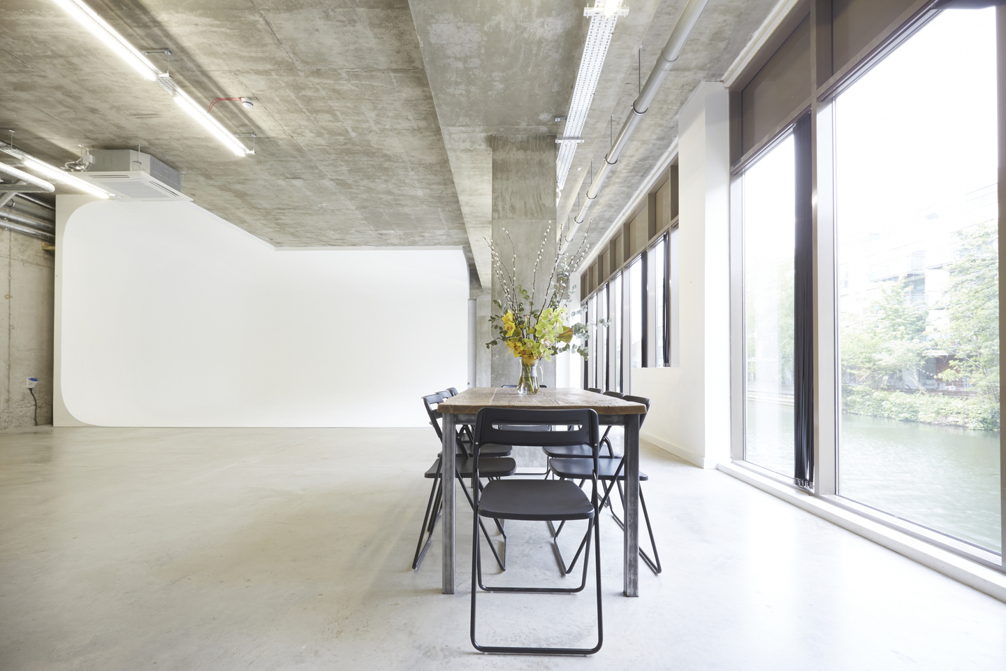 Modern minimalist meeting space with long table, ideal for workshops and brainstorming.