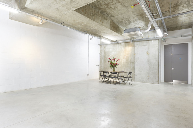 Versatile minimalist event space in LOCK Studios with floral decor for meetings and workshops.