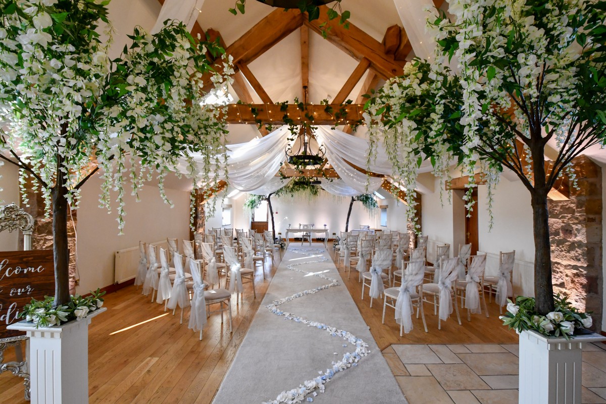 Elegant wedding venue at Beeston Manor with floral decor and wooden beams.