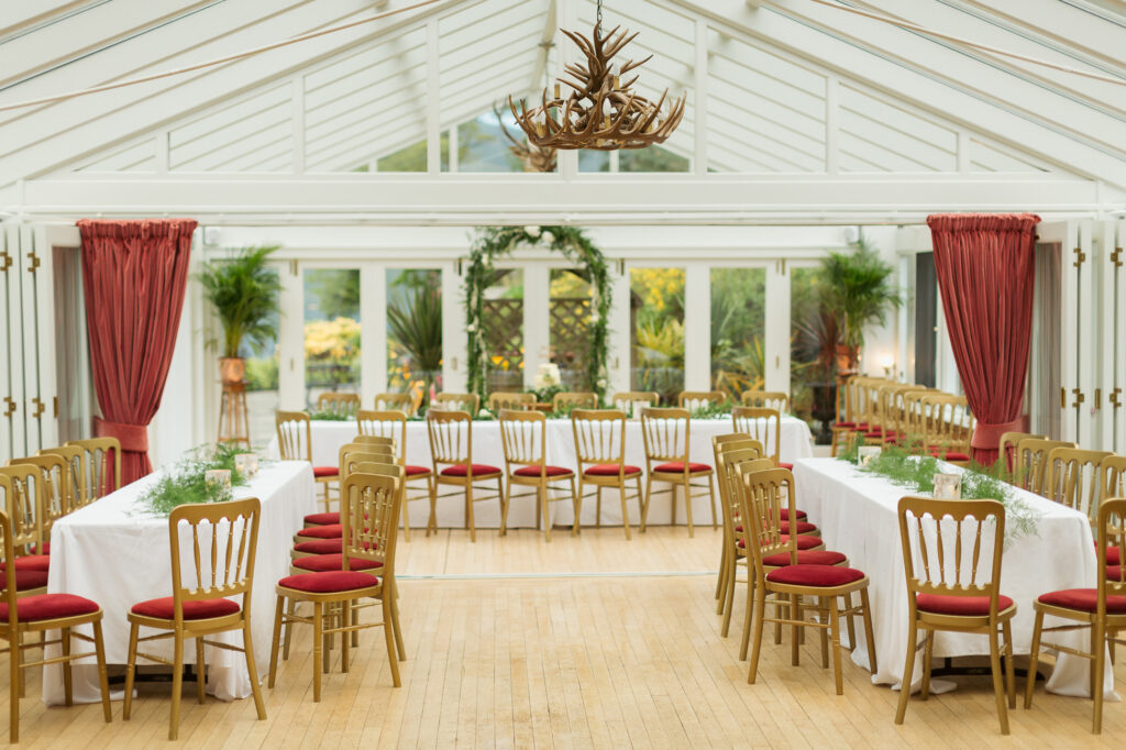 Elegant event space at Woodside Lodge with long tables and red accents. Perfect for gatherings.
