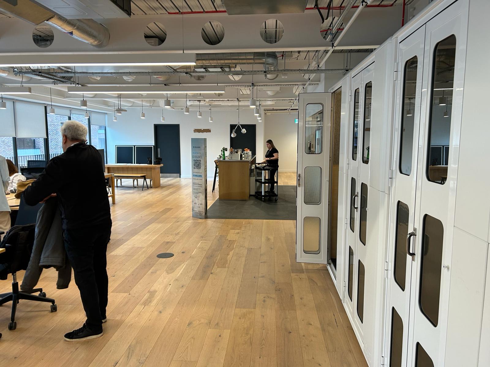 Modern event space in Shoreditch with open layout and private booths for meetings.