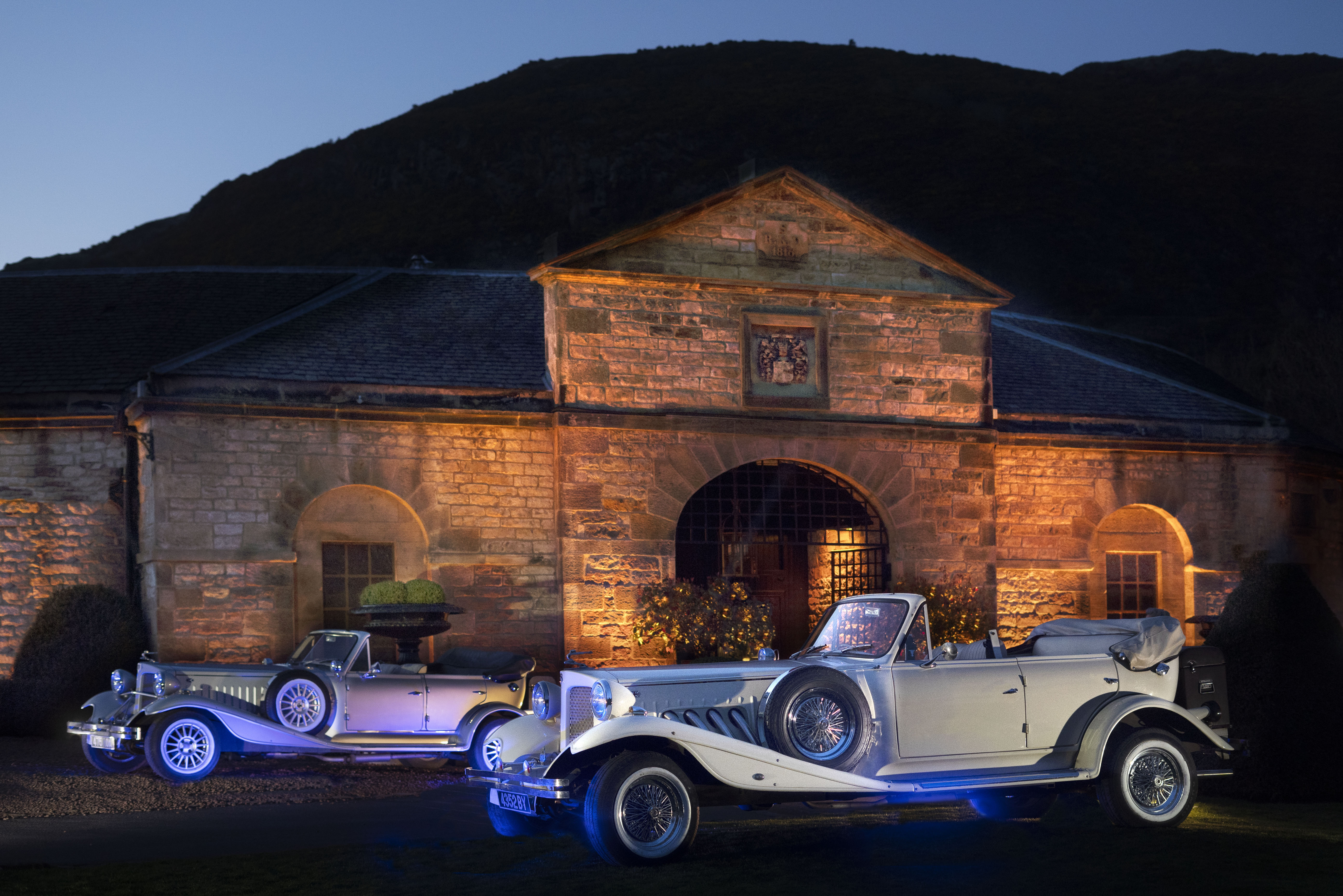 Prestonfield Stables Ballroom with vintage cars, ideal for upscale weddings and events.
