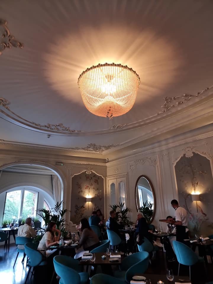 Elegant meeting space at The Pompadour with chandelier, ideal for events and gatherings.