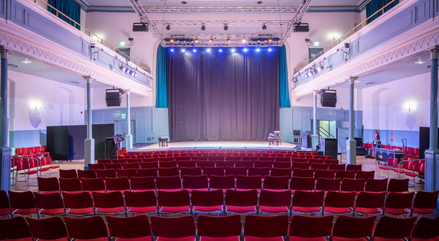 Auditorium in The Queen's Hall with spacious stage, ideal for conferences and performances.