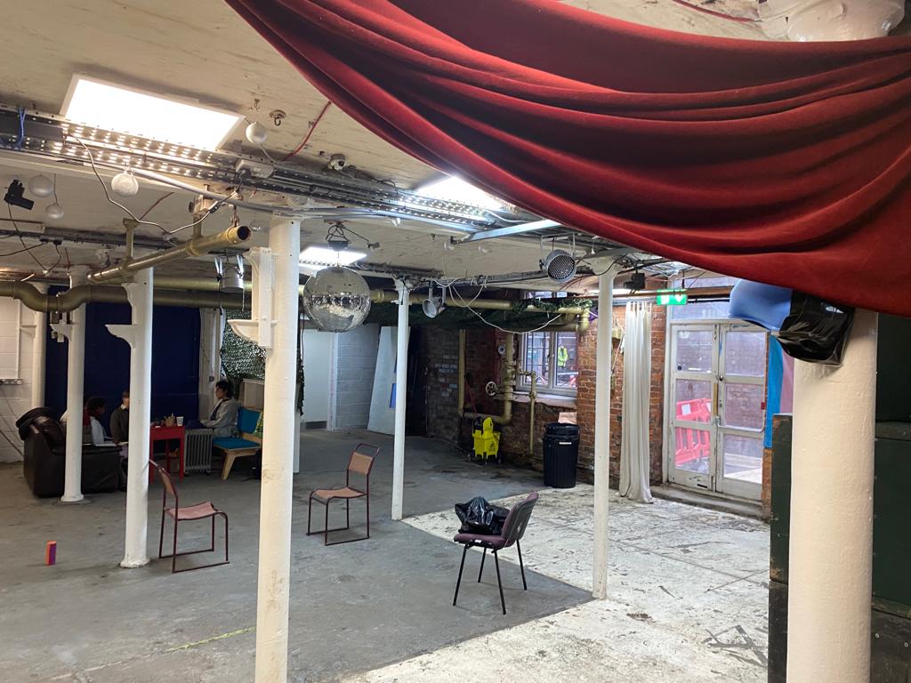 Versatile industrial event space with exposed beams, ideal for gatherings and meetings.