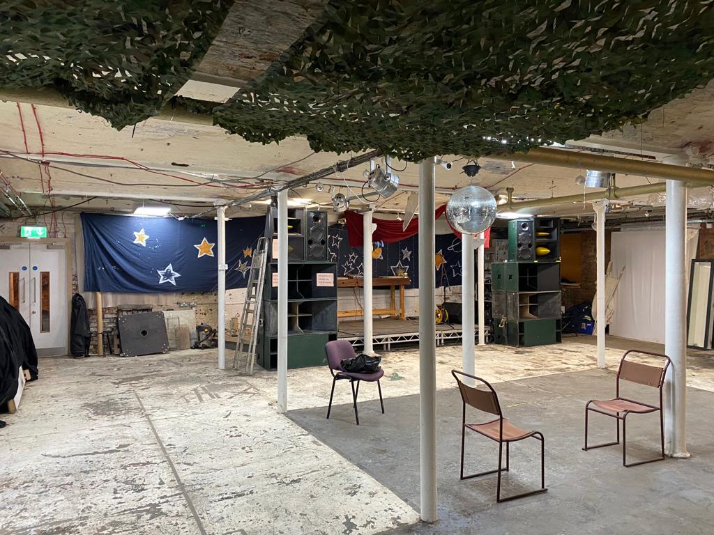 Versatile industrial event space with exposed beams, ideal for parties and themed events.