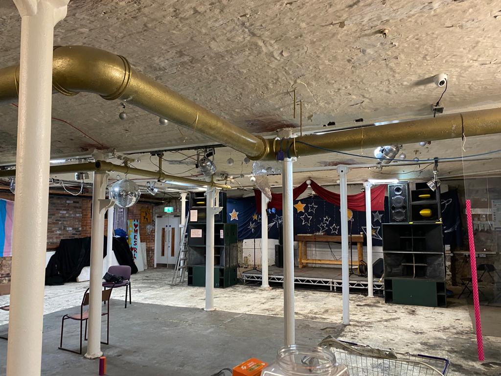 Partisan Venue with gold piping, ideal for events and performances in an industrial space.