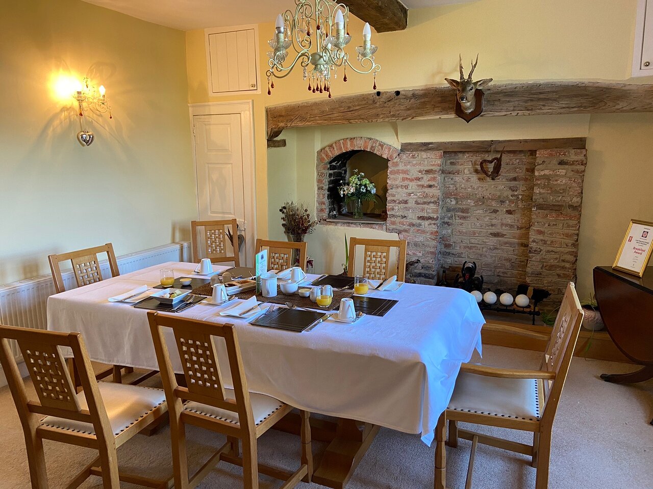 Intimate meeting space with elegant table settings and cozy fireplace at Low Osgoodby Grange.