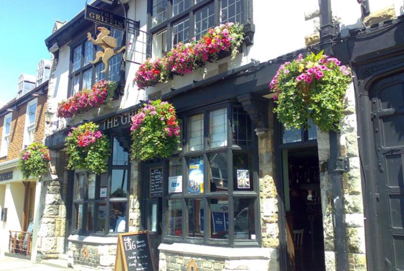 Charming pub exterior with flower baskets, perfect for casual gatherings and networking events.