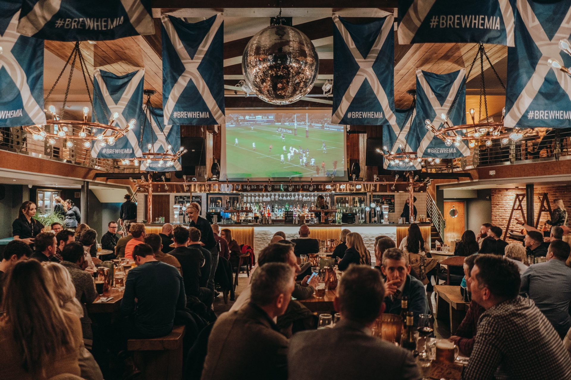 Beer Palace in Brewhemia: lively event space with Scottish flags for social gatherings.