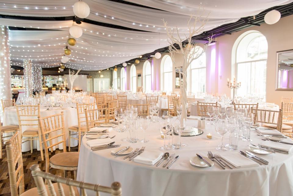 Landscaped gardens at Eskmills Venue, elegant wedding setup with round tables and soft lighting.