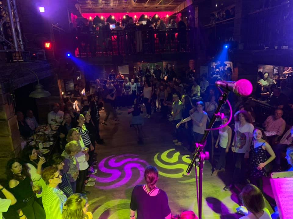 Vibrant dance floor at Stramash event with dynamic lighting and lively crowd.