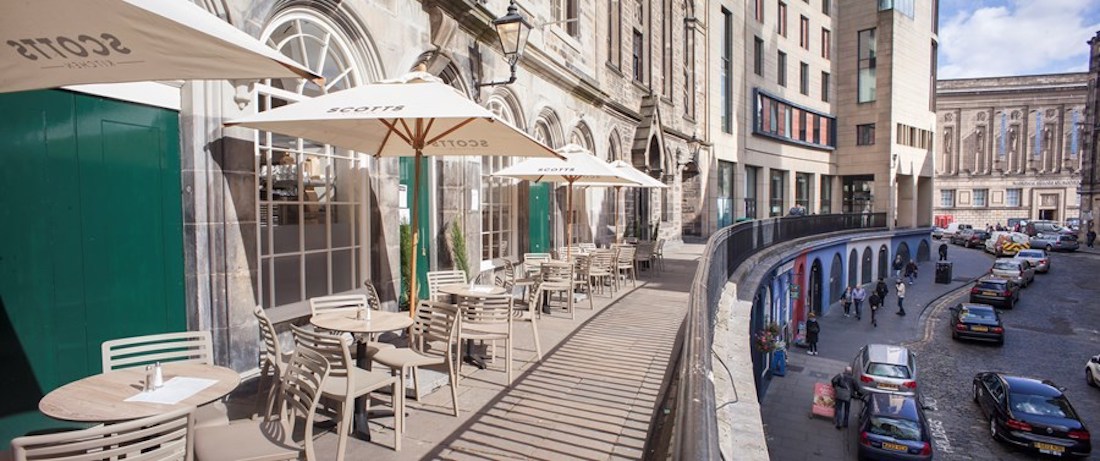 Outdoor terrace at Scotts Kitchen with umbrellas, perfect for casual meetings and networking events.
