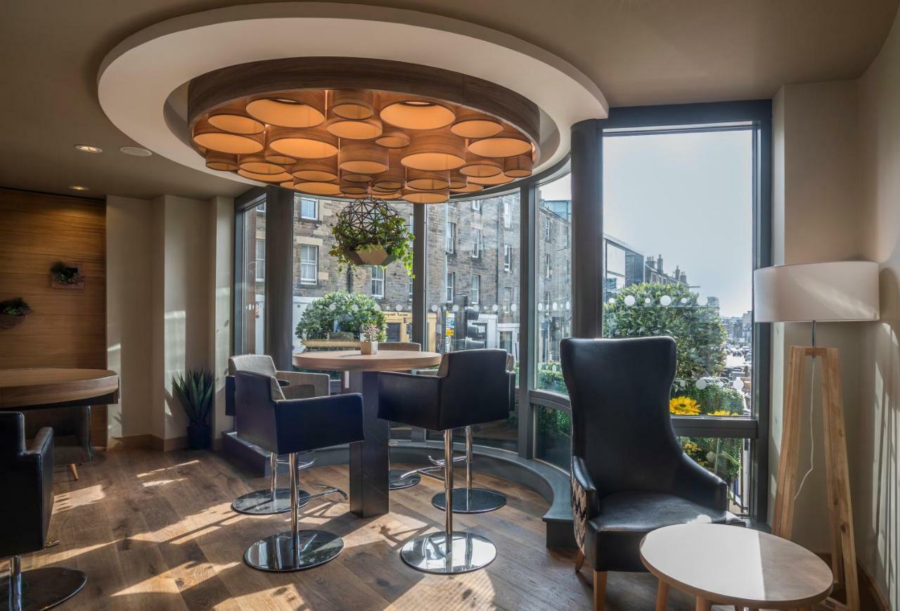 Modern meeting space at Point A Hotel Edinburgh with natural light and circular light fixture.