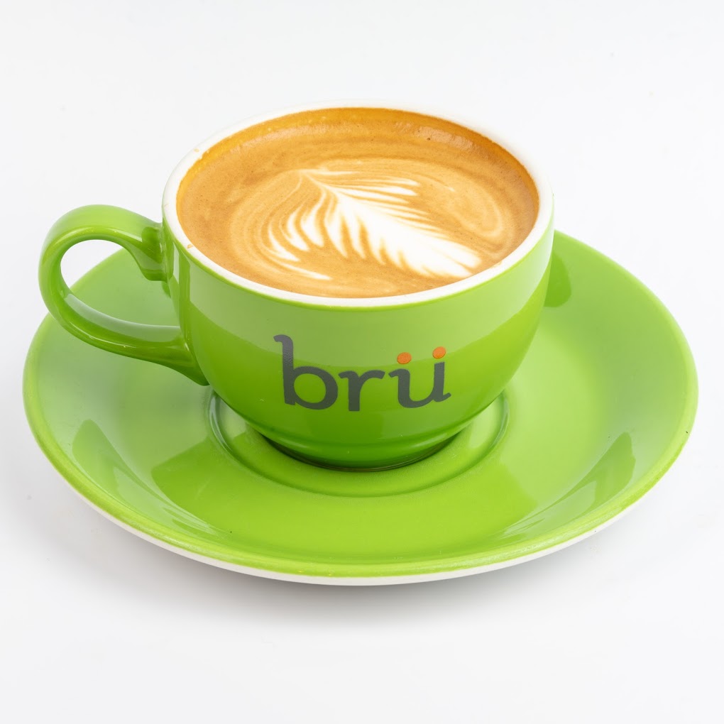 Vibrant green coffee cup with latte art, perfect for meetings and networking events.