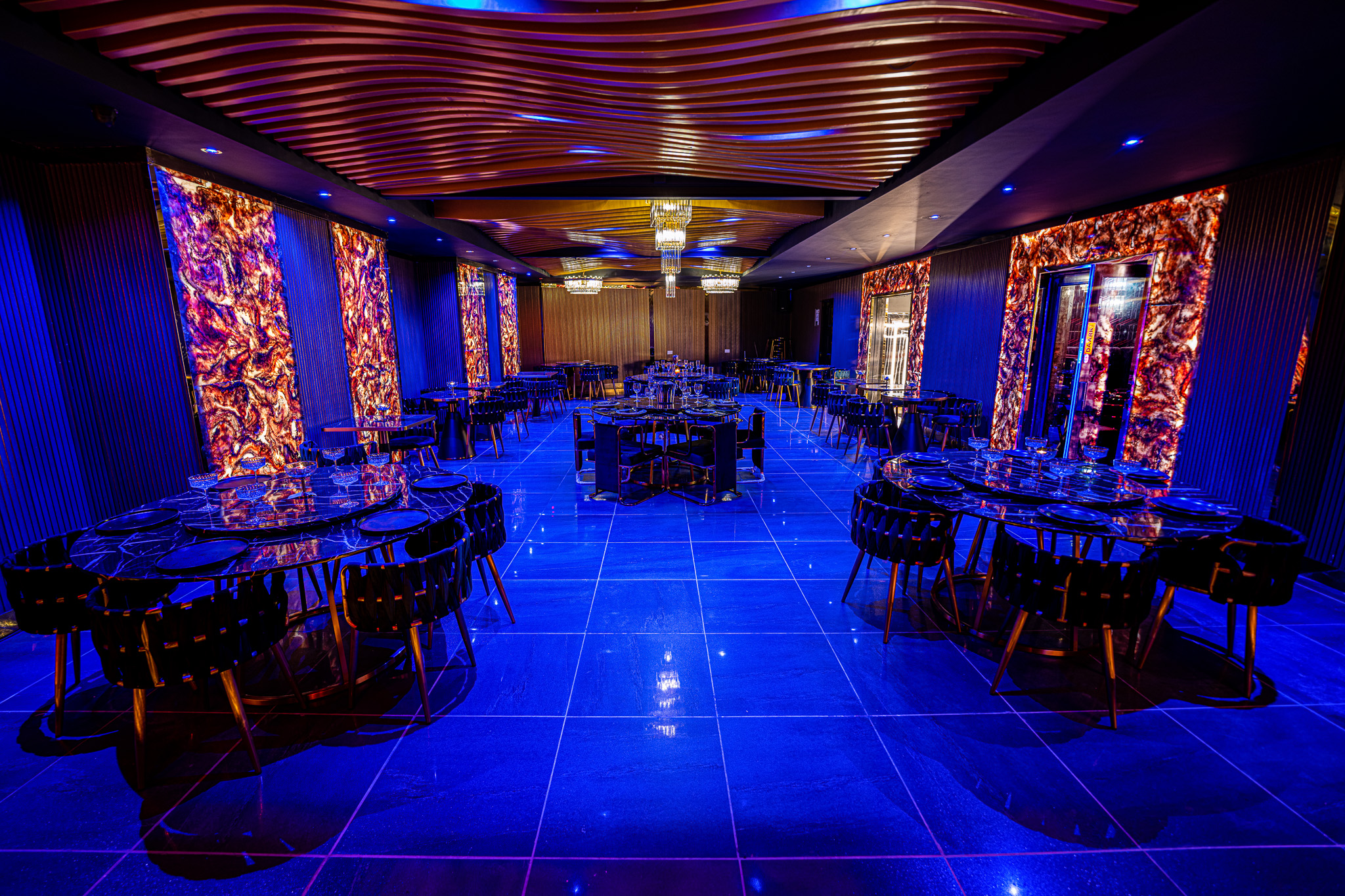 Modern event space with ambient blue lighting for corporate events and galas.