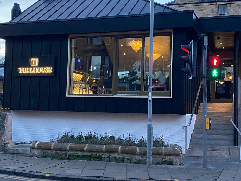 Private dining room at The Tollhouse, modern venue with large windows for events.