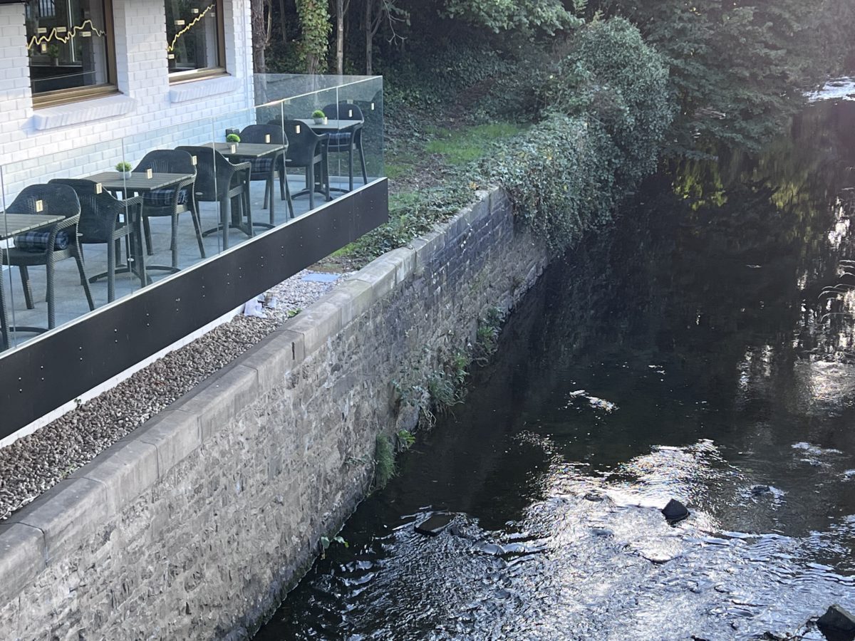 Serene outdoor terrace by waterway, perfect for casual meetings and networking events.