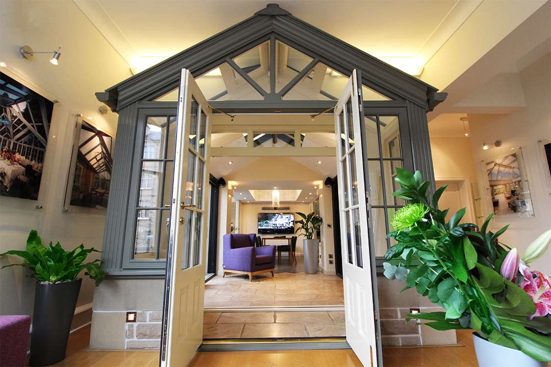 Modern event space entrance with large doors and greenery in BMA Scotland Conservatory.