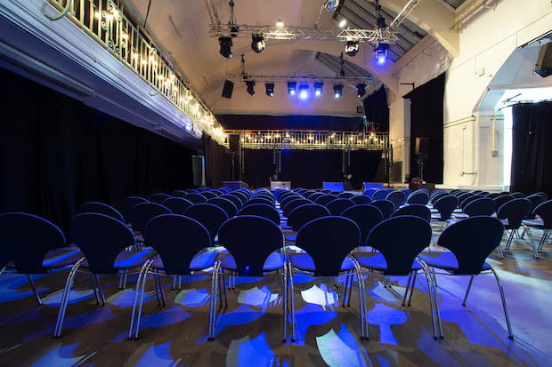 Breakout room with modern chairs and blue lighting for conferences or workshops.