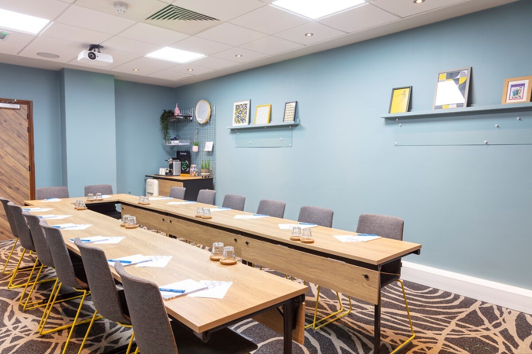 Meeting room with long table, notepads, ideal for workshops and team meetings.