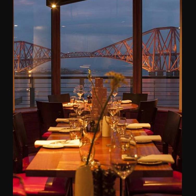 Elegant dining table at Orocco Pier with bridge views, perfect for events and gatherings.