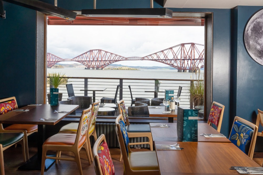 Vibrant Orocco Pier dining area with bridge view, perfect for events and gatherings.