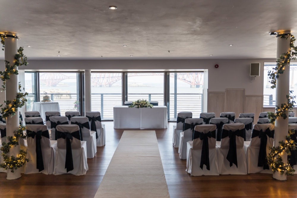Elegant wedding venue with white chairs and floral decor at Orocco Pier.