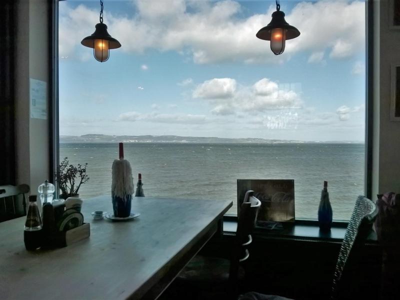 Serene waterfront meeting space with large window, ideal for creative events and gatherings.