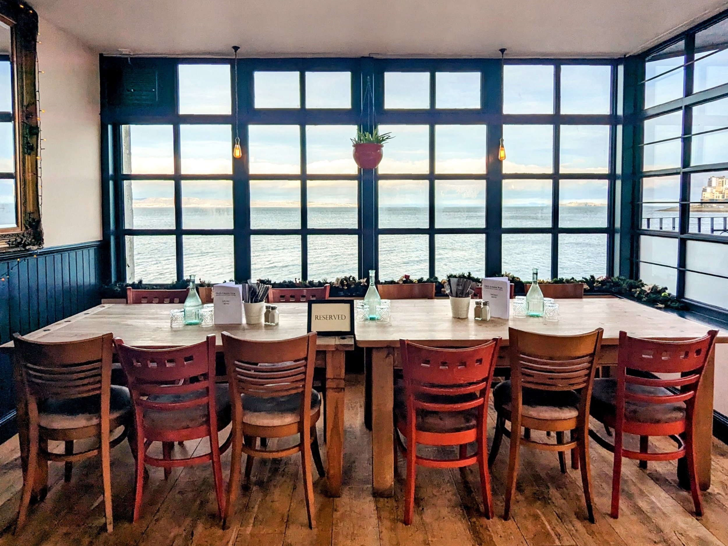 Intimate meeting space with long table and water view, perfect for corporate retreats.