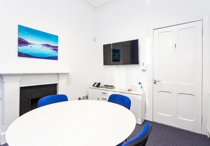 Modern boardroom with round table, ideal for meetings and presentations.
