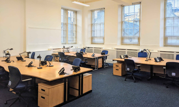 Versatile meeting room with workstations, ideal for collaboration and workshops.