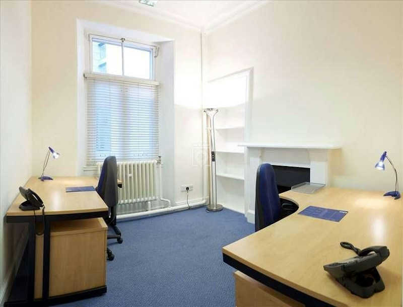 Minimalist serviced office space with desks, ideal for meetings and productivity.