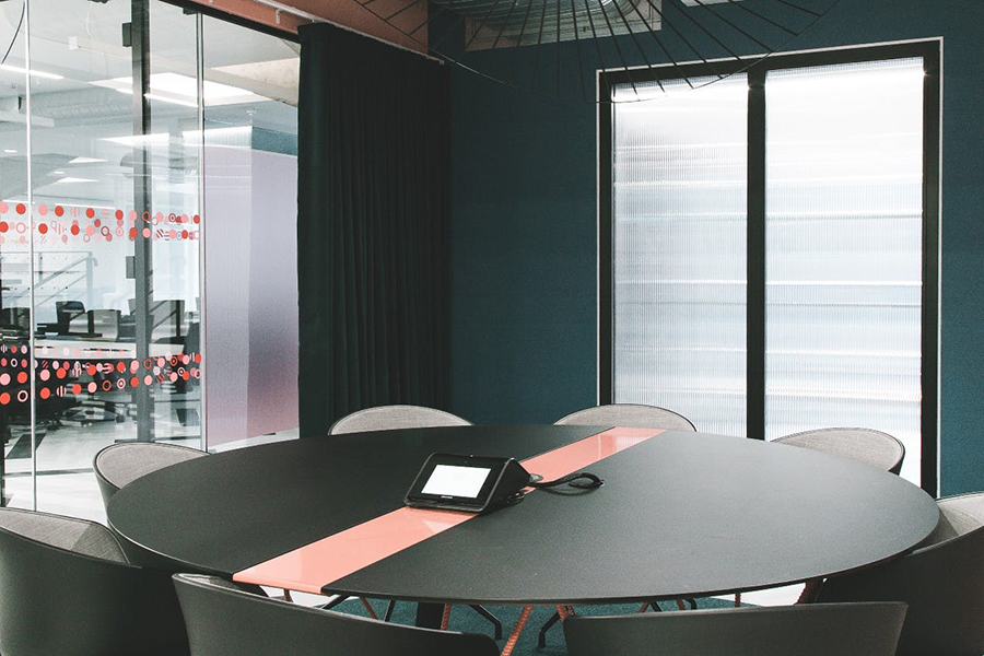 Modern meeting room with round table, ideal for conferences and presentations.