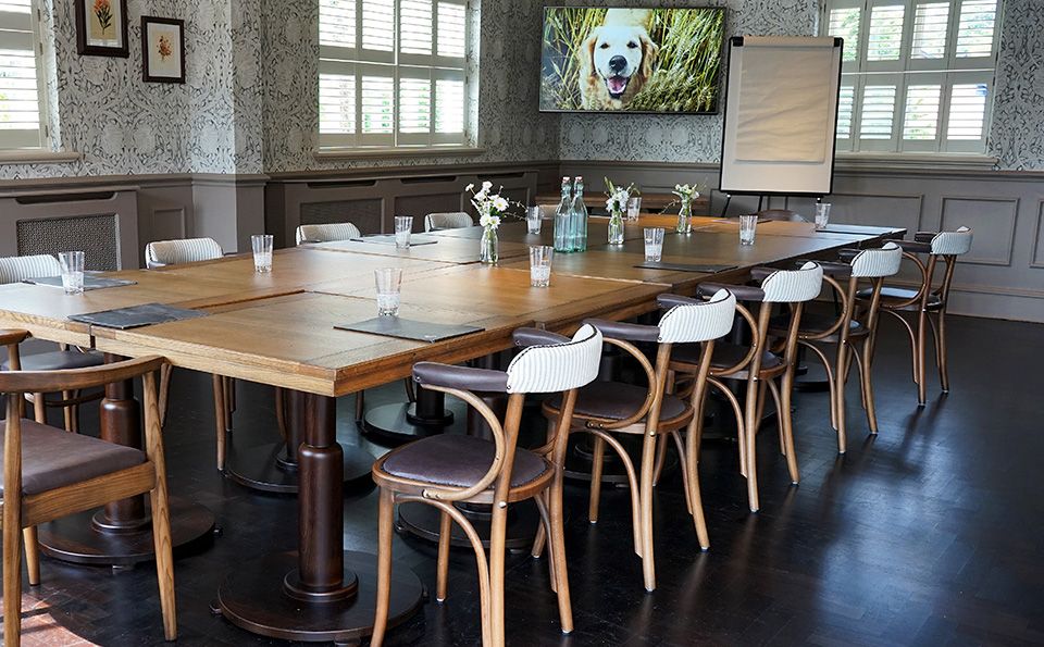 Private function room with wooden table, ideal for workshops and meetings.