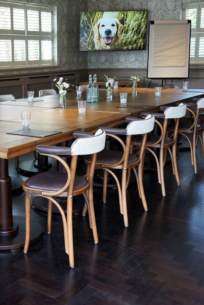 Private function room with long wooden table, ideal for meetings and events.