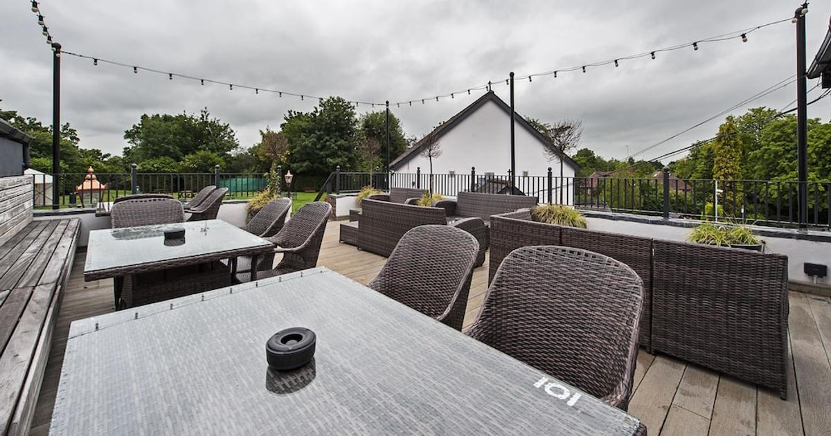 Private function room at Bulls Head with wicker furniture, ideal for outdoor events.