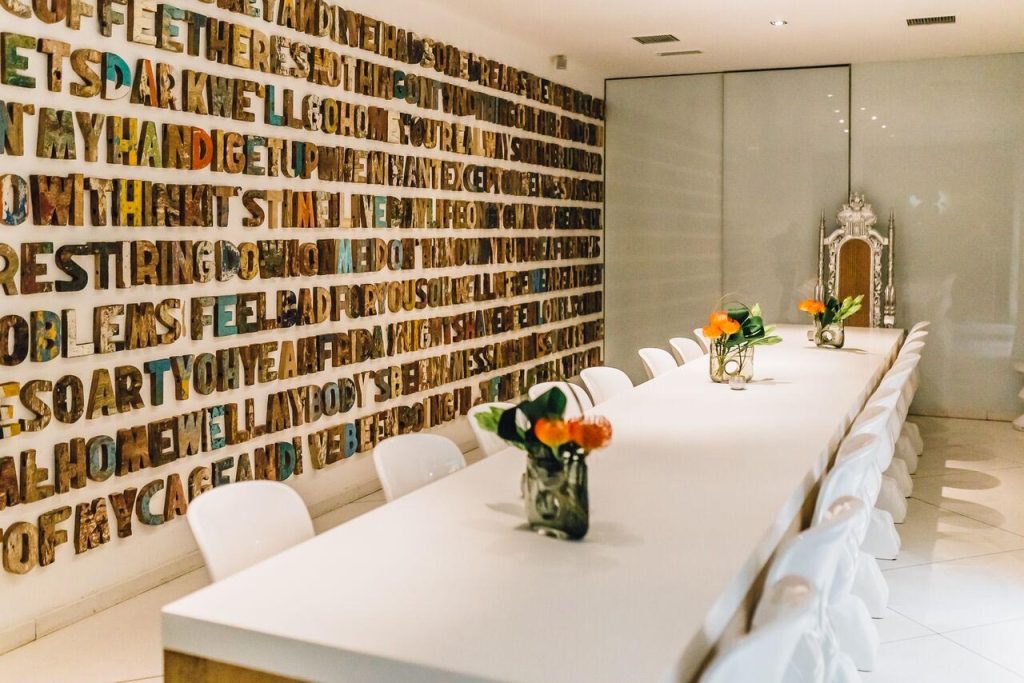 Private event space with sleek white table and colorful wall at The Corinthian Club.