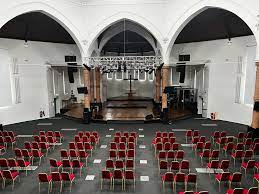 Modern event venue with large stage and seating for conferences or performances.