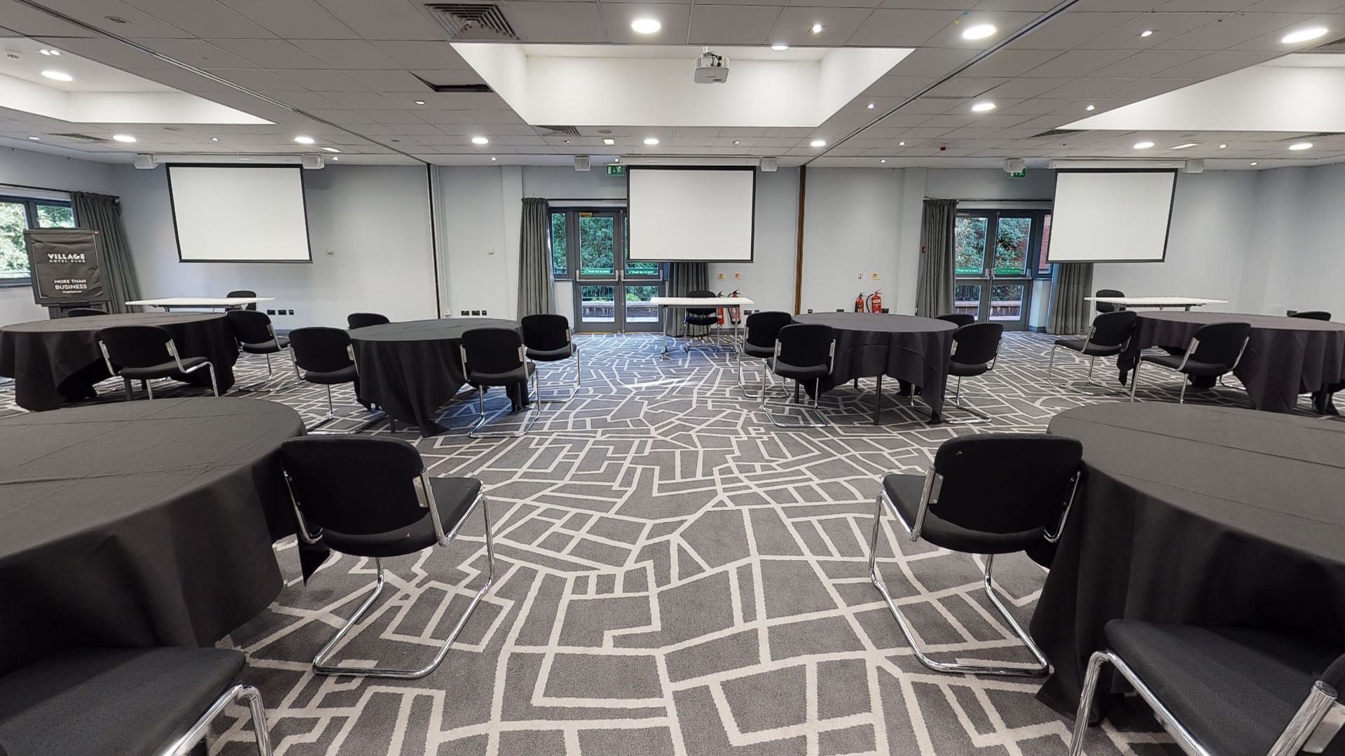 Versatile meeting space at Village Hotel Bury with round tables for workshops and presentations.