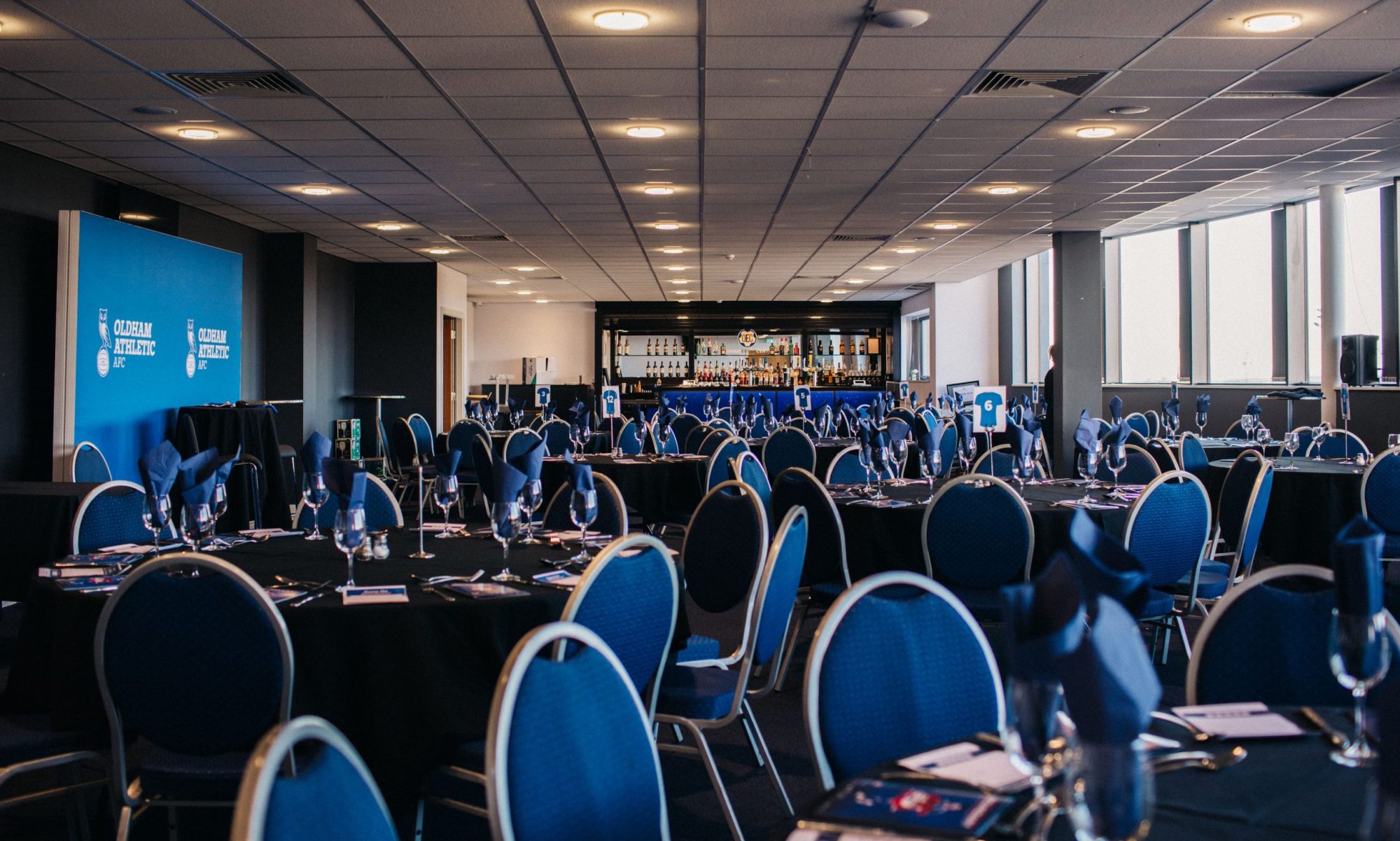 Event space in Oldham with round tables, blue napkins for corporate meetings or galas.