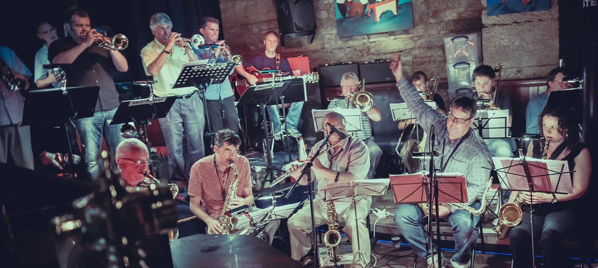 Live music stage with diverse musicians at The Jazz Bar, perfect for entertainment events.