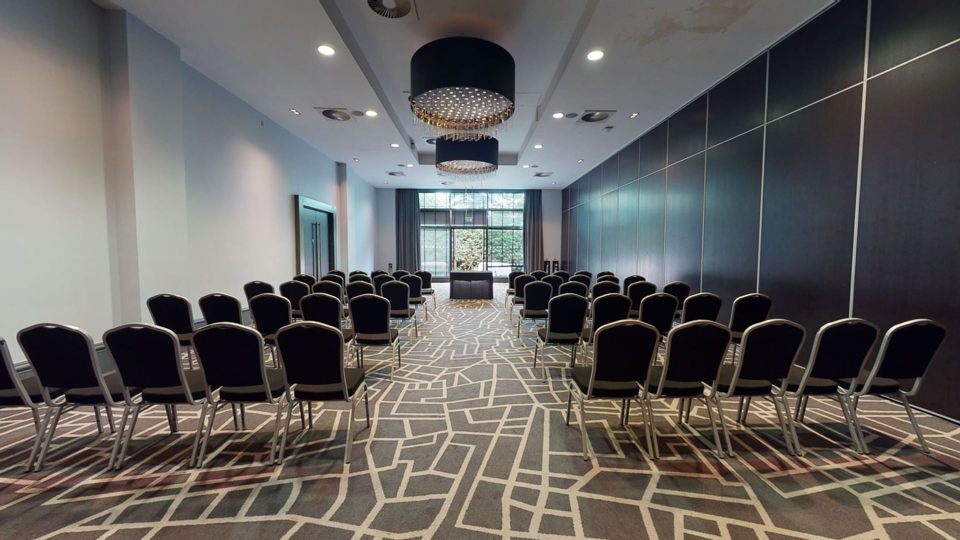 Meeting room at Village Hotel Edinburgh, featuring black chairs for corporate seminars.