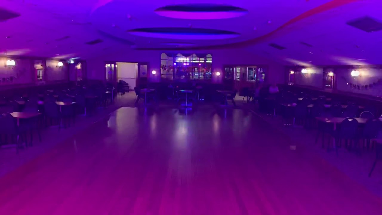 Spacious function hall with polished wooden floor, ideal for events and gatherings.