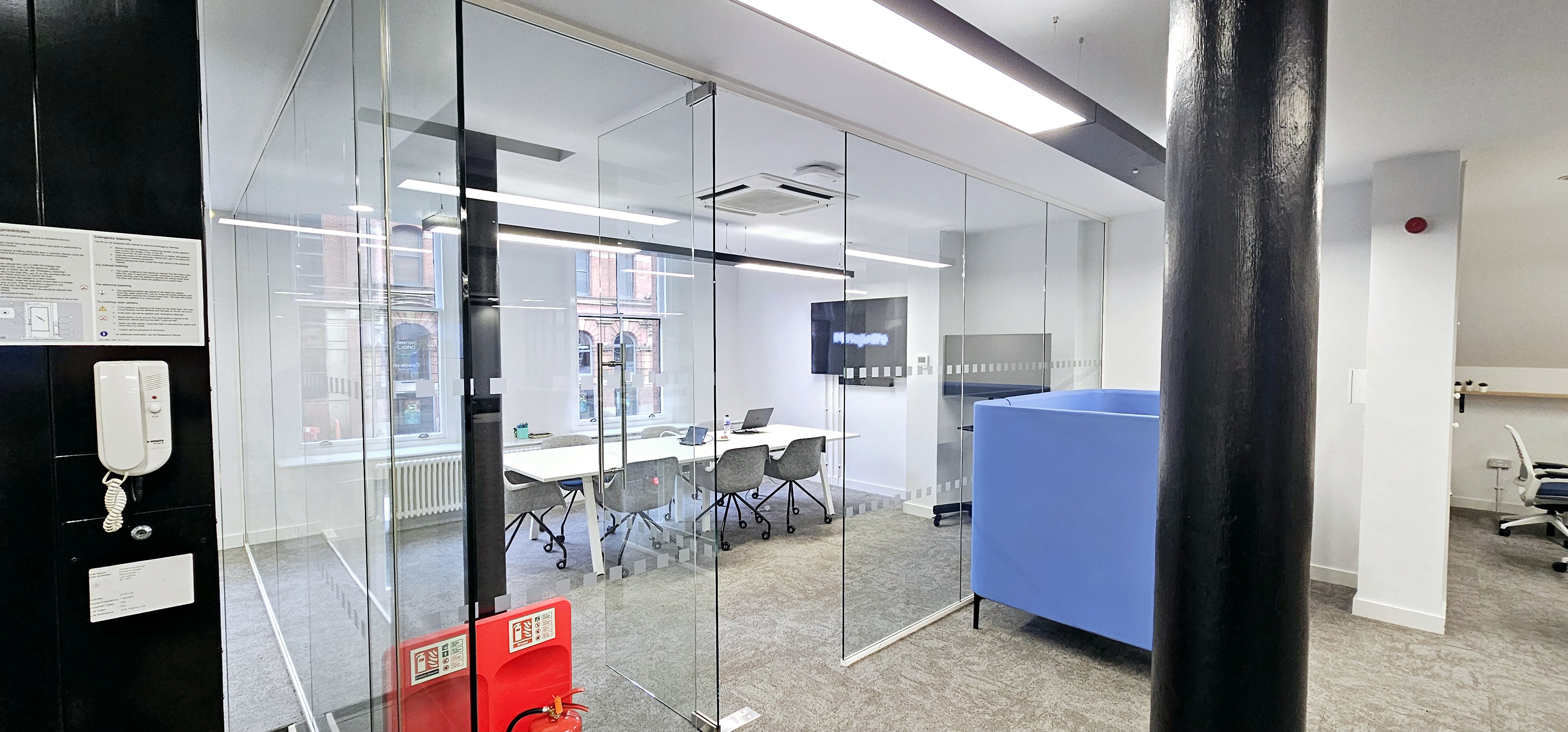 Modern meeting room with glass walls for collaboration at ZEBOX UK, ideal for brainstorming.