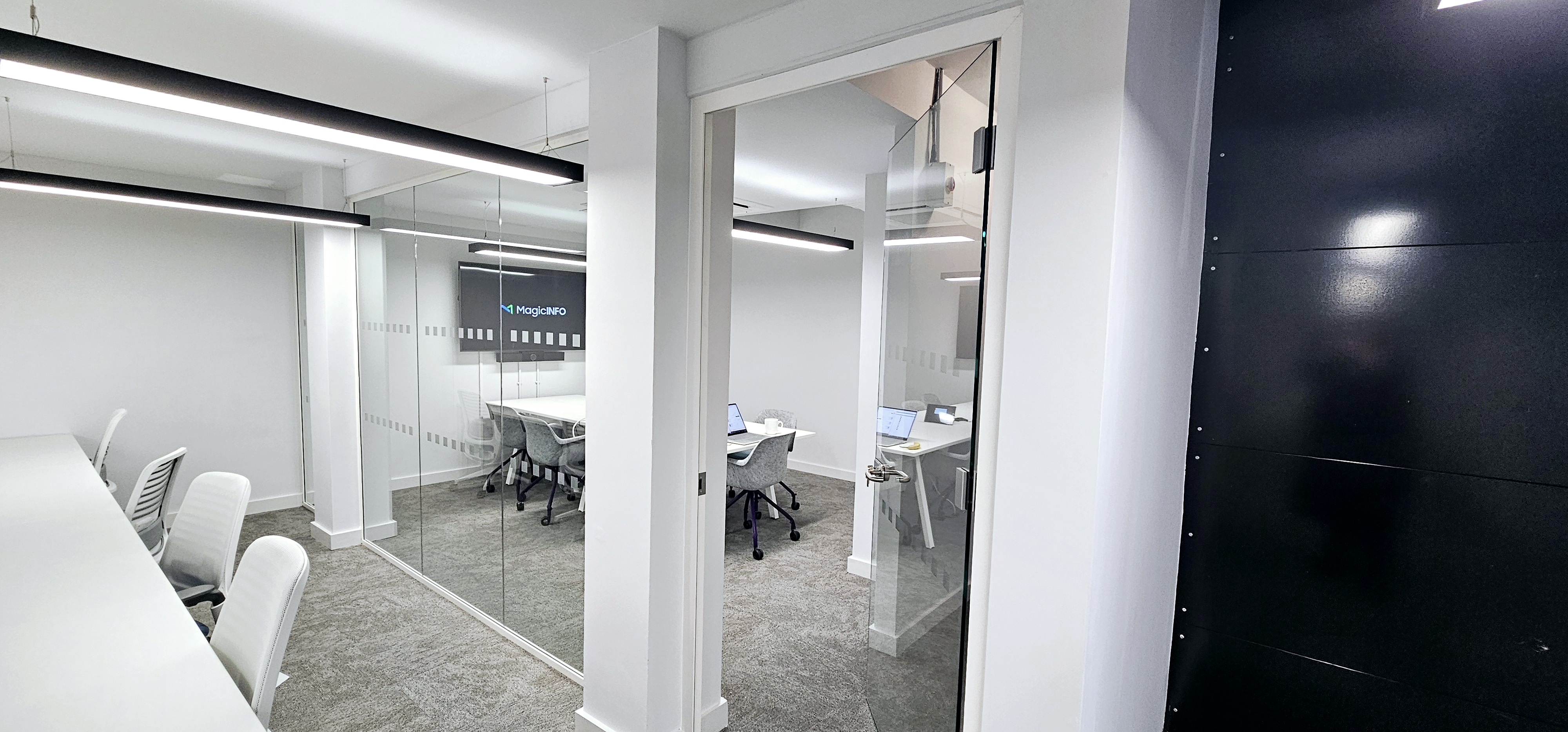 Modern meeting room with glass walls, ideal for collaborative sessions and presentations.