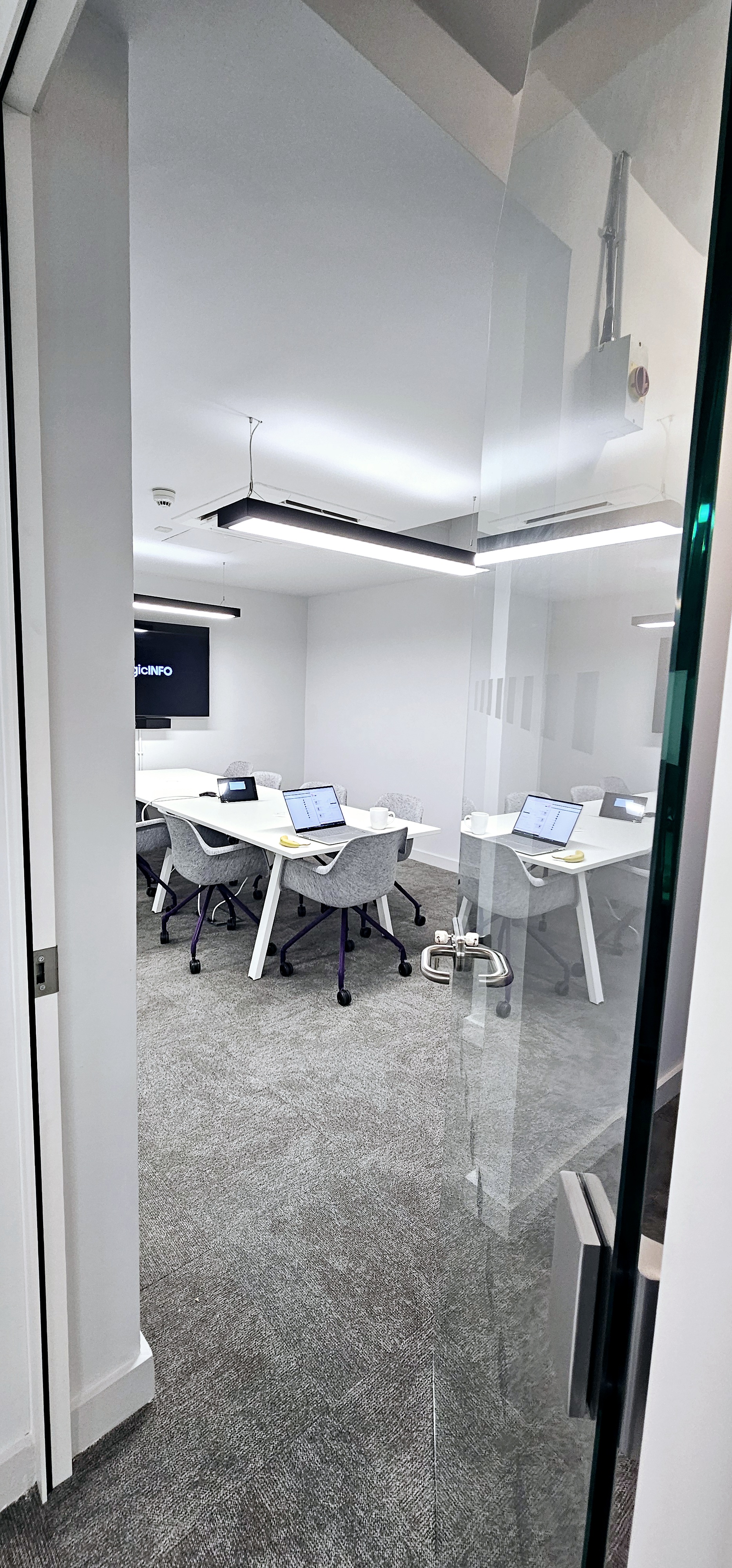 Modern meeting room with sleek table, glass walls for collaboration and presentations.