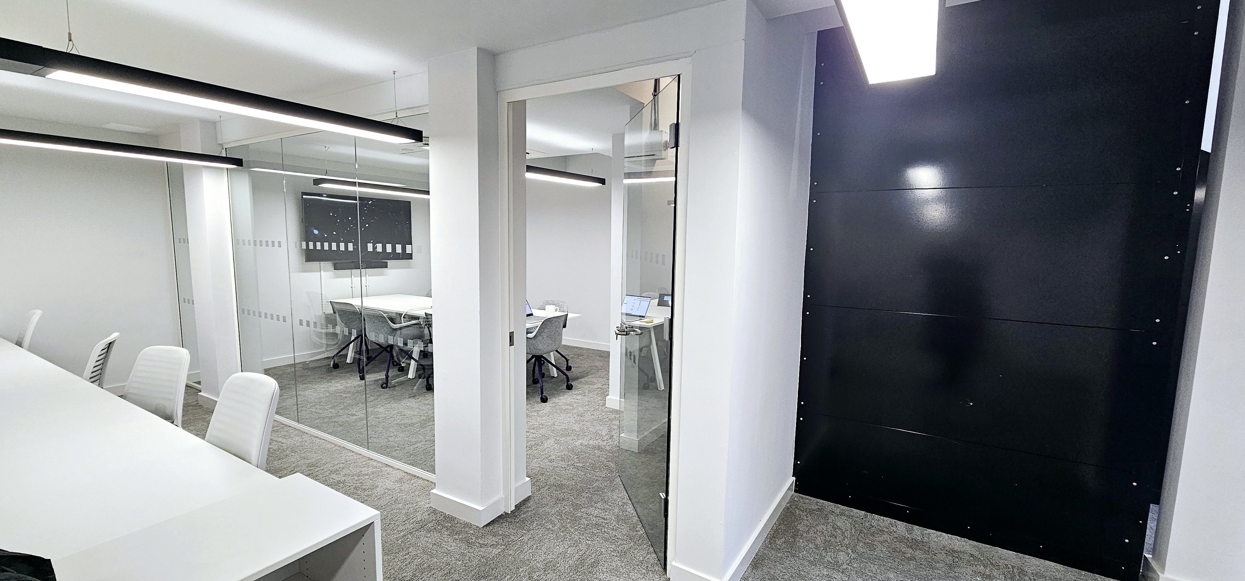 Modern meeting room with glass walls, ideal for collaborative sessions and client meetings.