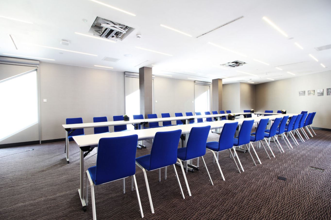 Modern U-shaped meeting room in Marlowe with blue chairs for collaborative discussions.